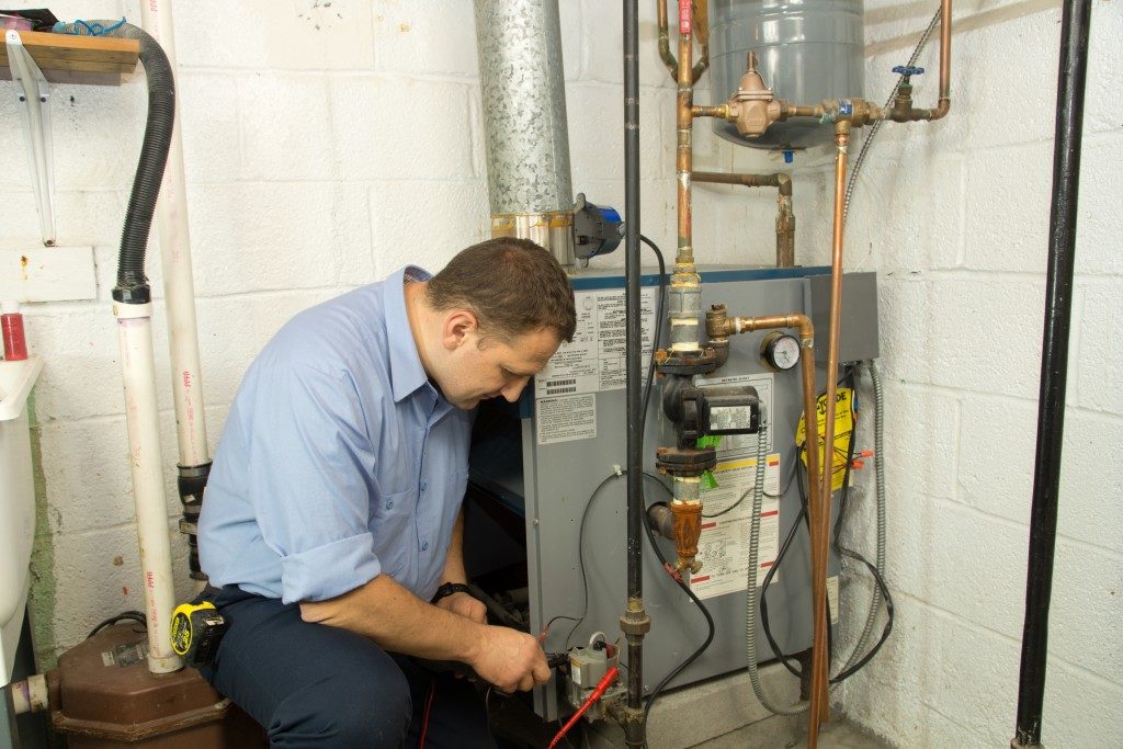 Plumber fixing the gas furnace