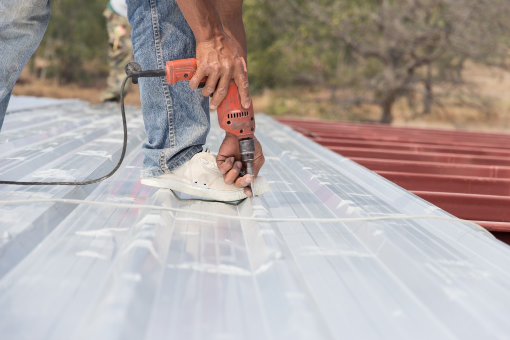 worker installing metal roof