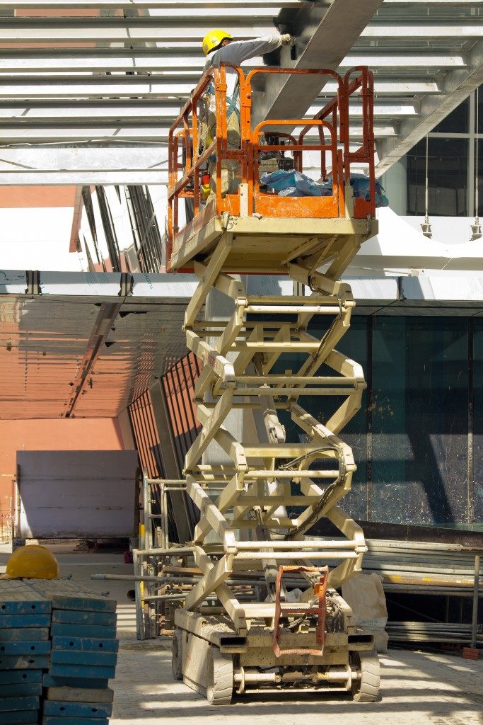 Construction worker Painting Beam using Hydraulic Scissor Lift