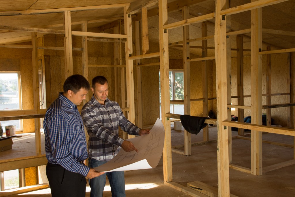 two men holding a house blueprint