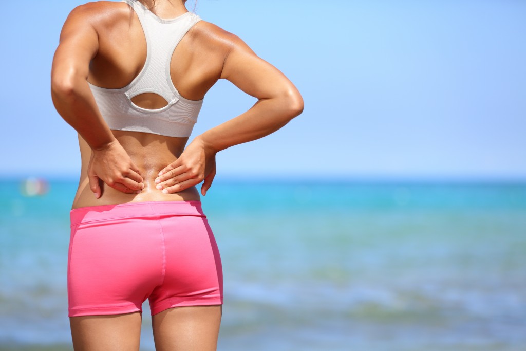 Woman experiencing back pain while running