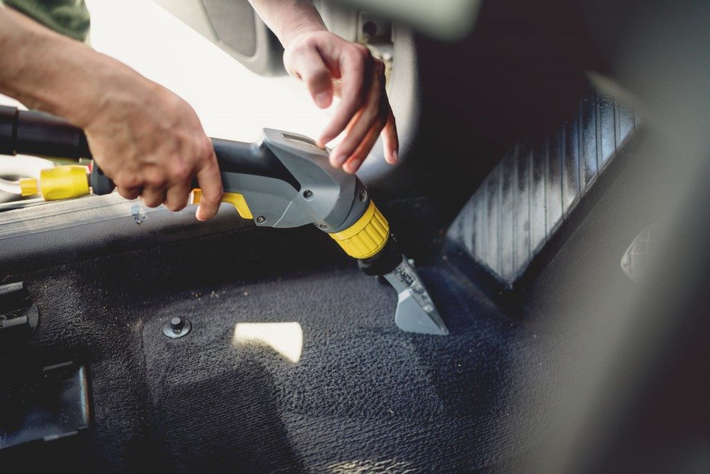 man vacuuming his car