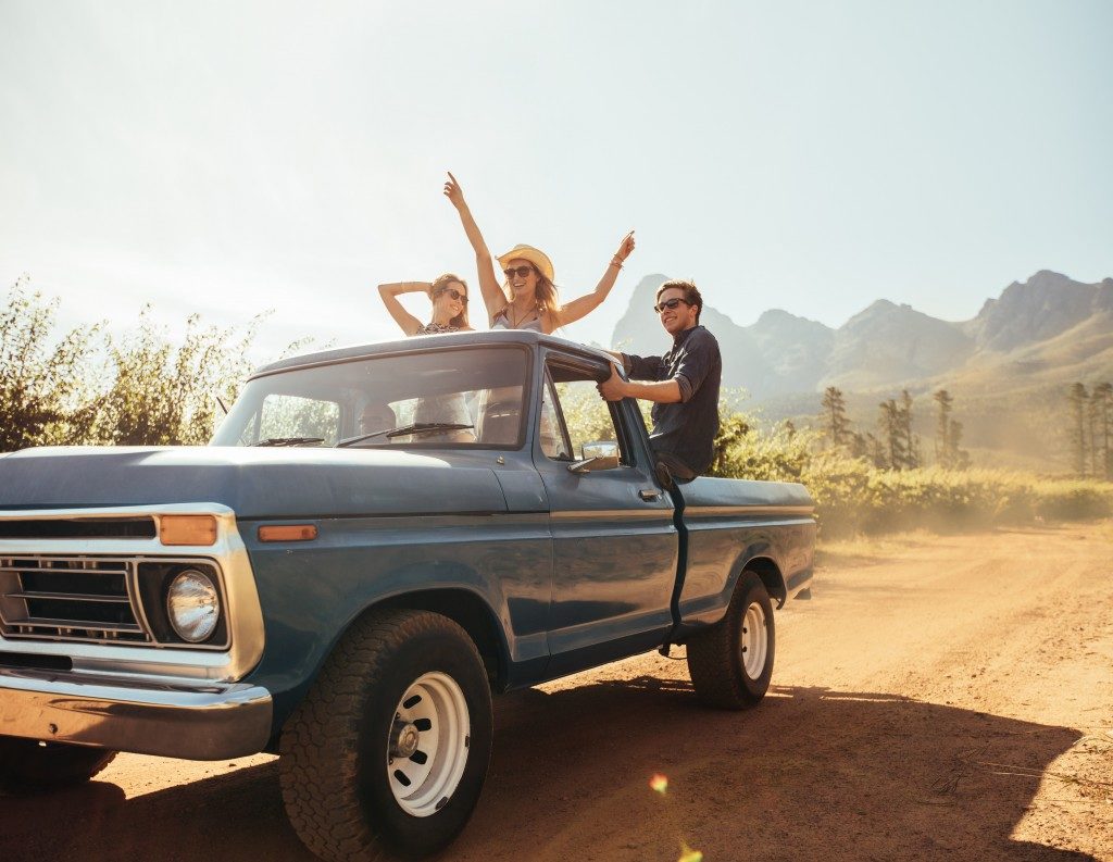 Group of people at the back of a pick up truck having fun