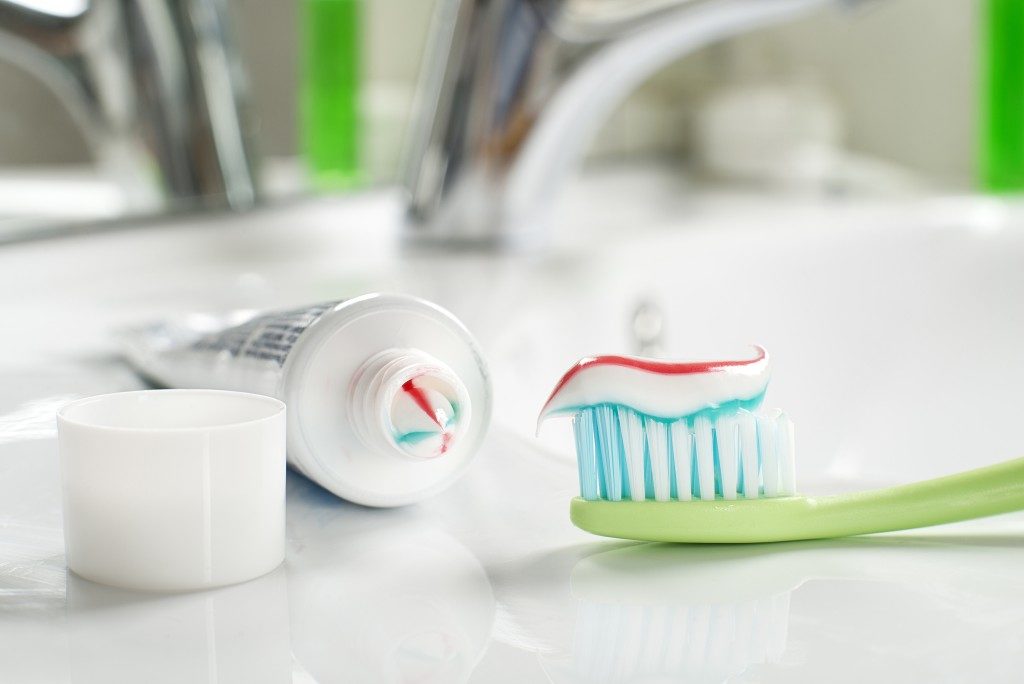 Toothbrush and toothpaste in the bathroom close up