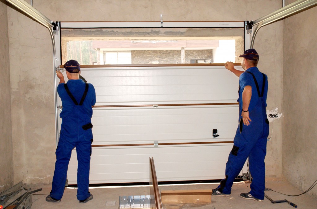 men installing the garage door