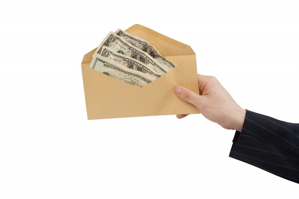 woman holding out cash donation envelope