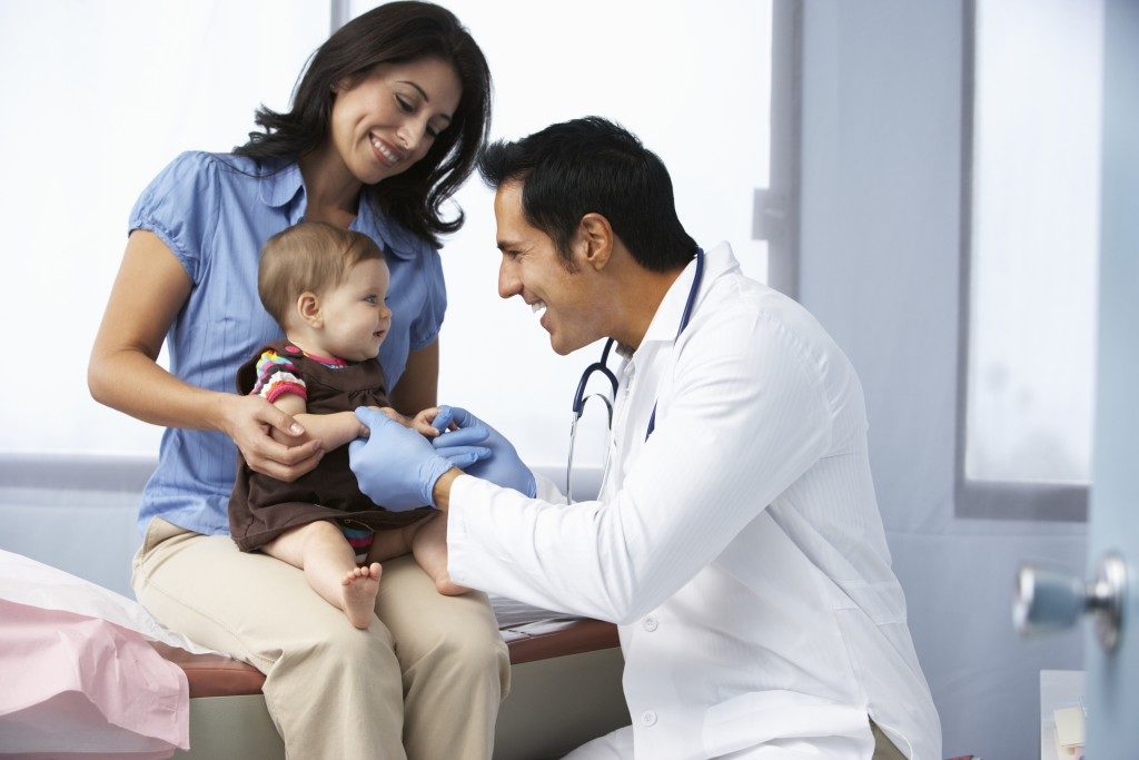 mother having her child check by a doctor