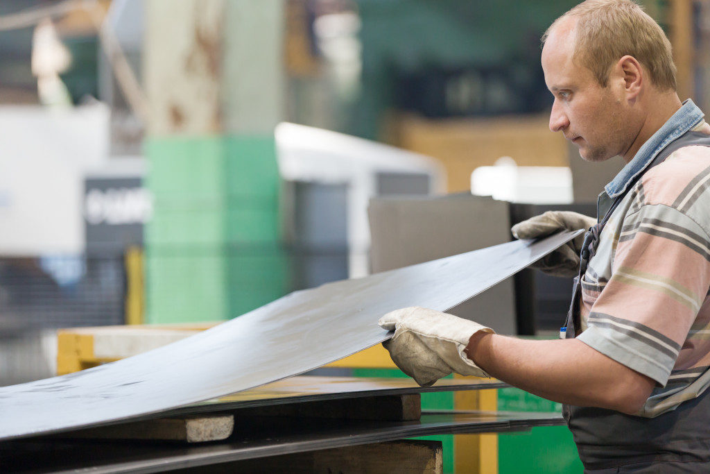 Worker holding sheet of metal