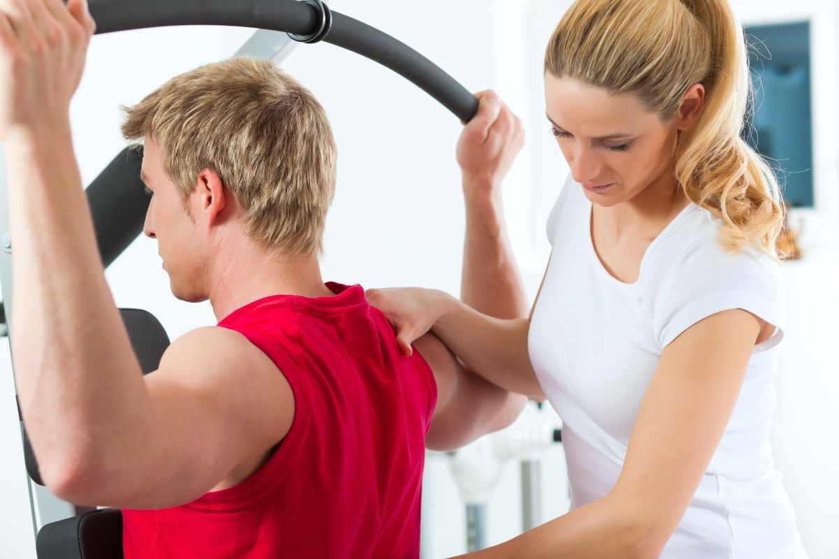 man exercising with physician behind