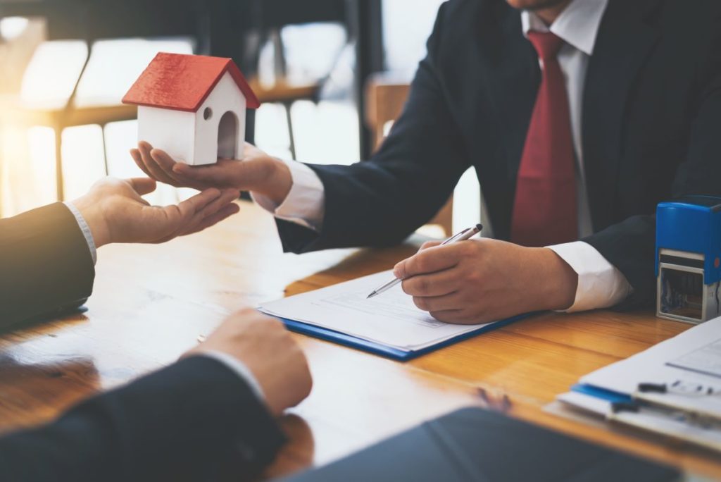 man holding miniature house model