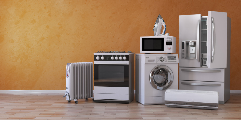 a row of different kitchen appliances in orange background