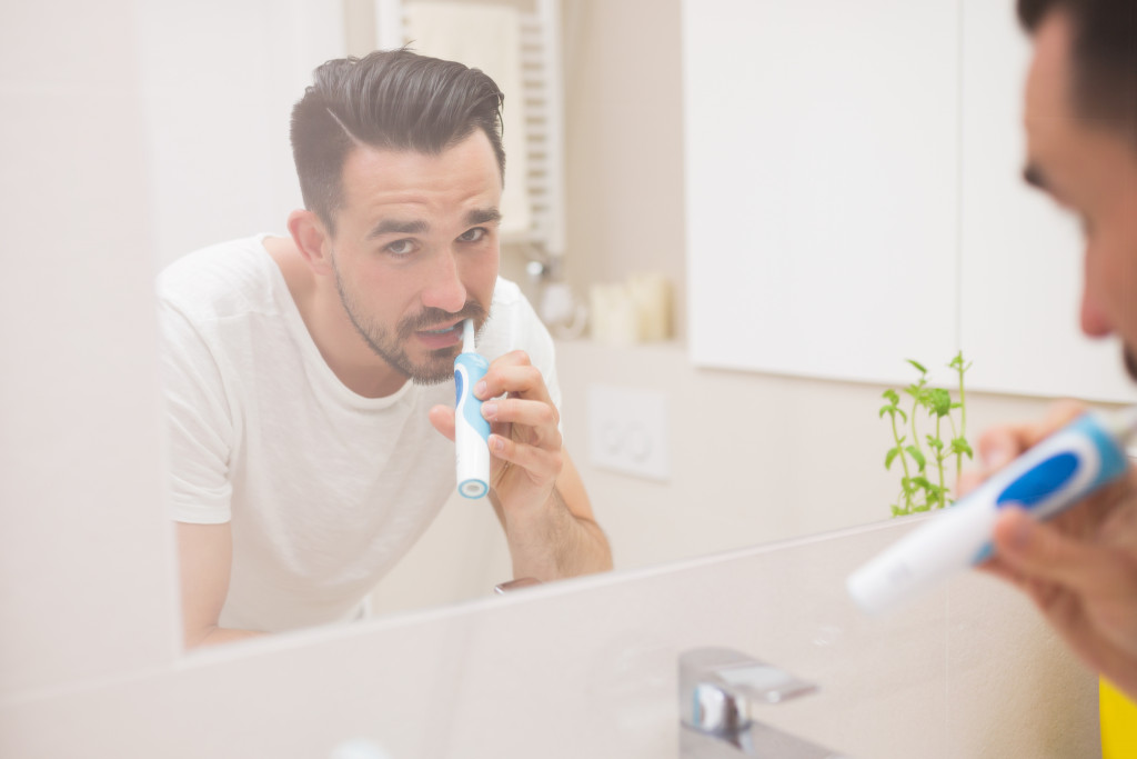 man harshly brushing his teeth