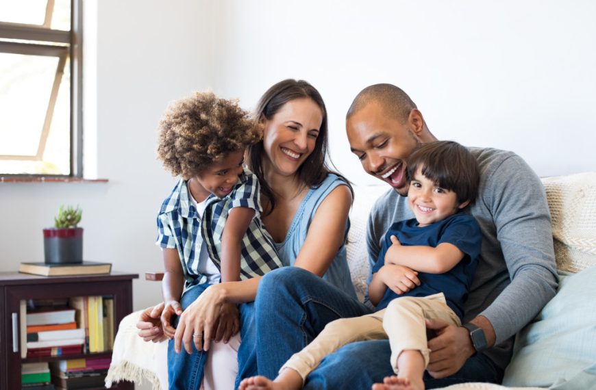 happy family with two young boys in the living room couch