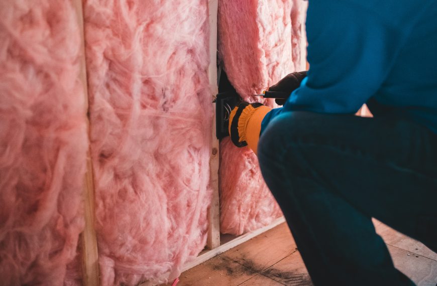 man insulating a wall
