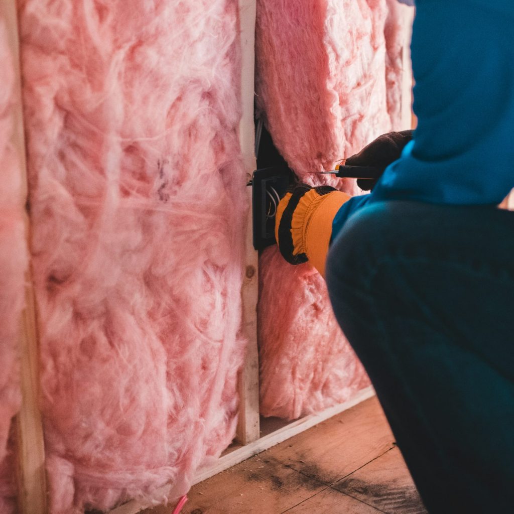 man insulating a wall