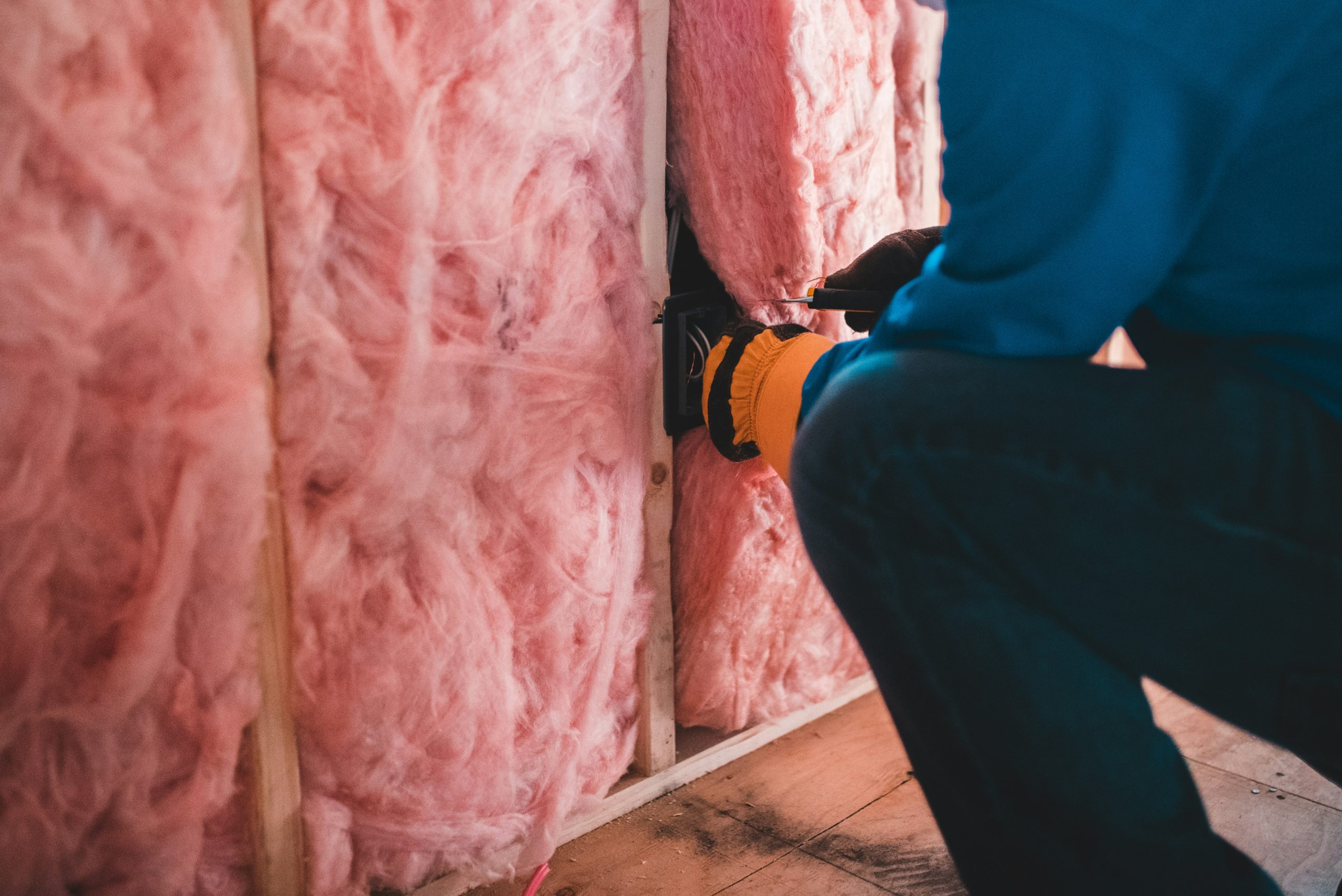 man insulating a wall